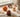 Four autumn-themed squishy toys — a fox, an acorn, a spiked hedgehog-shaped piece and an orange maple leaf — arranged together on a wooden desk in soft window light.