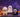 Three Halloween squishy figures — a masked hooded ghost, a white ghost buddy and a bandage-wrapped mummy — arranged on foggy stone steps with pumpkin lanterns