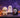 Three Halloween squishy figures — a masked hooded ghost, a white ghost buddy and a bandage-wrapped mummy — arranged on foggy stone steps with pumpkin lanterns