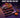 Official TABASQUISHY Halloween display box featuring pumpkin squishy toys in round, clear containers, set against a deep purple studio background, with the poster-style slogan "VERIFY BEFORE YOU BUY" at the top.